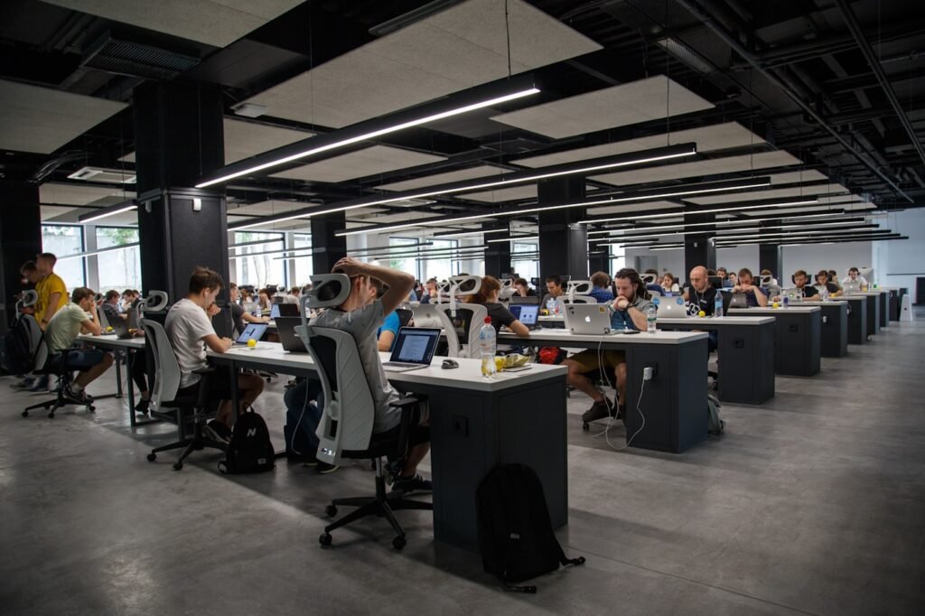 Piso de oficina abierto con decenas de puestos de trabajo y portátiles