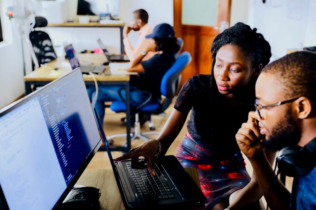 Dos personas revisando código en una pantalla durante una sesión de formación